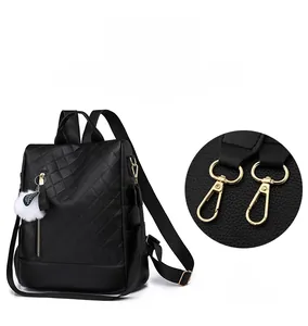 Detail of detachable golden lobster clasp and soft black quilted leather on a PU backpack