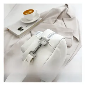 Detailed shot of premium metal hardware and fabric strap on a soft white PU leather handbag