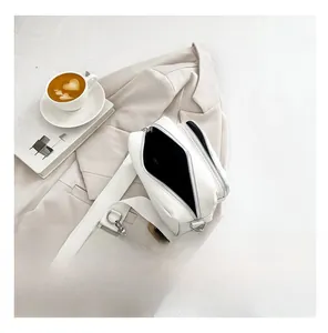 Close-up of white PU leather crossbody bag with dual zippers and a small round coin purse