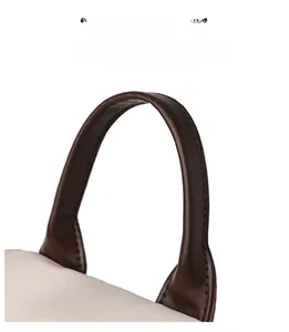 Détail de la poignée ergonomique en cuir marron foncé avec coutures fines sur le sac
