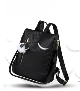 Detail of lightweight black quilted PU leather backpack with a fluffy plush ball pendant