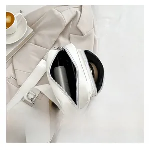 Detailed interior of a white PU leather crossbody bag showing dual zipper storage compartments