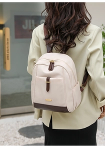 Vue détaillée d'un sac à dos en tissu beige avec des accents en cuir marron