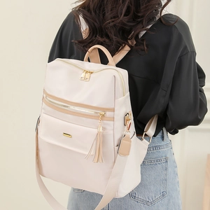 Chic beige anti-theft backpack for women with stylish tassel and gold hardware