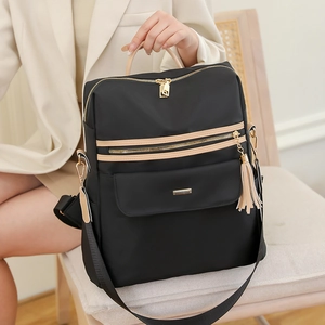 Chic black anti-theft backpack for women with beige tassels and golden metal hardware details
