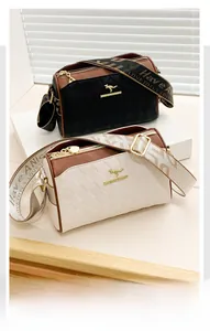 Detail of diamond lattice pattern leather handbag with metallic logo and wide woven strap