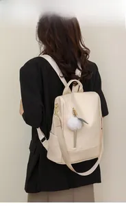 Creamy white quilted PU leather backpack with gold zippers and plush pendant detail