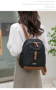 Vue détaillée du sac à dos en oxford noir avec détails en cuir marron et finitions dorées