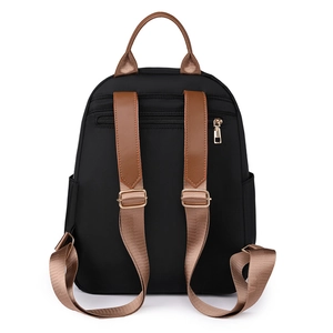 Détail du dos d'un sac à dos noir en oxford avec bretelles en cuir brun et zip antivol doré
