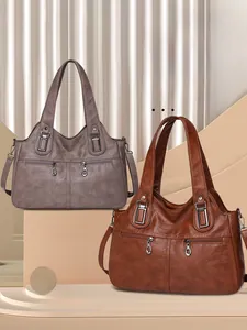 Detail view of large PU leather tote bags in taupe and brown with retro metal zippers