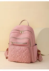Detail view of pink quilted nylon backpack featuring large capacity and gold zippers