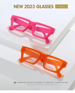Macro detail of thick square glasses frames in vibrant pink and orange finishes