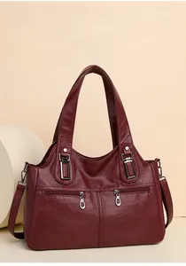 Detail of burgundy textured PU leather handbag with front vertical silver zippers