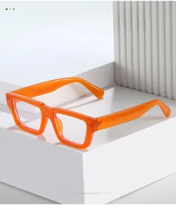 Detailed close-up of thick orange square eyeglass frames with glossy texture material