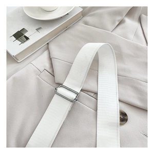 Detail of adjustable woven white shoulder strap with polished silver metal buckle