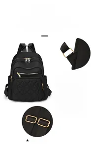 Detail view of black nylon backpack with gold hardware and diamond quilted front pocket