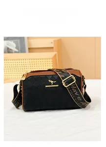 Detail view of quilted pillow bag with logo and wide patterned crossbody strap