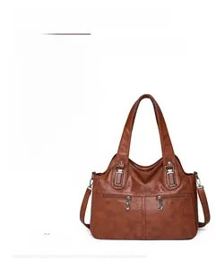 Detail of the durable metal hardware hook and adjustable strap on the brown tote bag