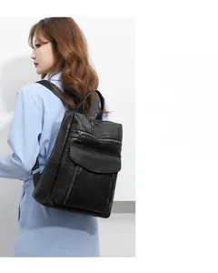 Detail of black pebbled leather backpack with multi-layer pockets and zipper closure