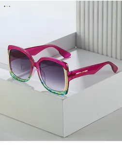 Detail of oversized pink sunglasses with gradient lenses and gold metal accents