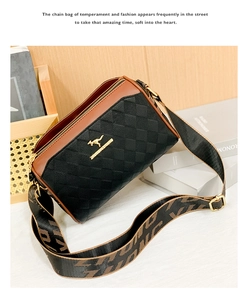 Detail of quilted leather pillow bag in black and brown with wide logo shoulder strap