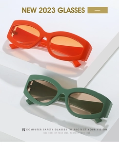 Detail view of stylish orange and green oval cat eye sunglasses on geometric stands