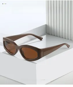 Detail view of brown oval cat-eye sunglasses with thick glossy plastic frame on white stand