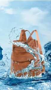 Close-up of waterproof brown faux leather backpack with water splash effect detail
