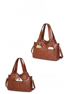 Detail view of brown leather handbag featuring dual front and rear secure zipper pockets