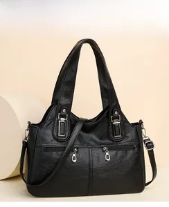 Close-up of black litchi pattern PU leather bag with silver hardware and dual zippers