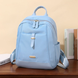 Sac à dos bleu ciel en nylon pour ordinateur 14 pouces posé sur une table en bois