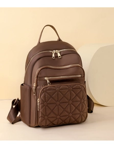 Detailed view of coffee brown quilted backpack with multi-zipper compartments