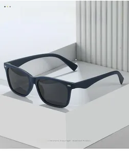 Close-up of matte navy blue square frame sunglasses with silver metallic rivets and polarized lenses