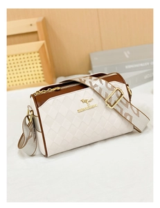Detail of brown and white quilted crossbody bag with adjustable wide letter strap