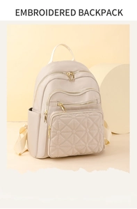 Macro detail of geometric quilted stitching and gold zipper on beige backpack