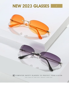 Close-up of orange and purple gradient rimless cat-eye sunglasses with gold metal temples