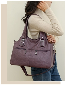 Detail of large purple soft leather tote bag with lychee texture and zipper pockets