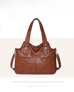 Front view of a brown soft leather tote with dual zippers and square ring buckles