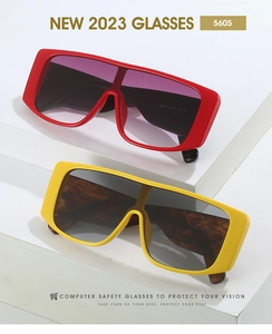 Detail of red and yellow oversized square sunglasses with gradient lenses on white display