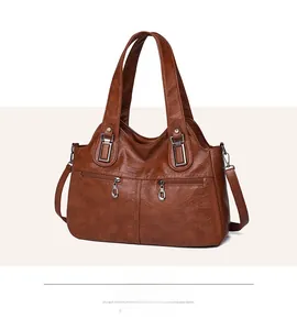 Detail view of brown PU leather handbag with dual horizontal zipper pockets and strap