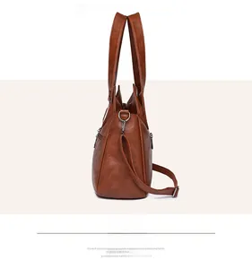 Detail view of large brown faux leather tote with pebble grain texture and side zipper