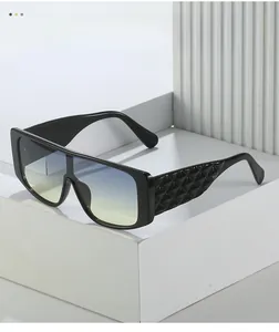 Detail view of large square sunglasses with 3D diamond texture and gradient blue lenses