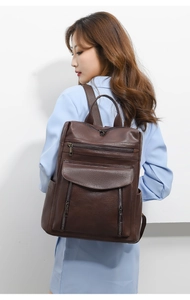 Retro dark brown large capacity faux leather backpack worn by model in light blue blazer