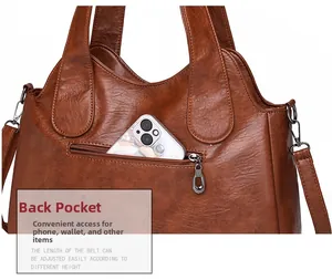 Detail of retro brown leather handbag showing back zipper pocket with a smartphone inside