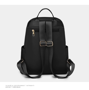 Detail of black nylon backpack featuring ergonomic straps and a secure anti-theft back pocket