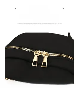 Detailed close-up of premium golden double metal zippers on a black commute backpack