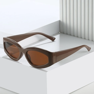 Minimalist cat eye sunglasses with retro brown oval frames on white modern stands