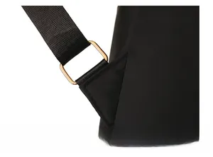 Detail of a black backpack showing durable shoulder strap with gold metal buckle attachment