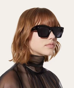 Détail de lunettes de soleil rectangulaires noires avec rivets sur un mannequin mode