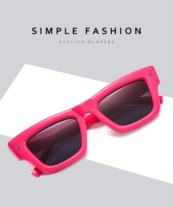Detail view of bold pink square frame sunglasses with metal studs and dark grey lenses